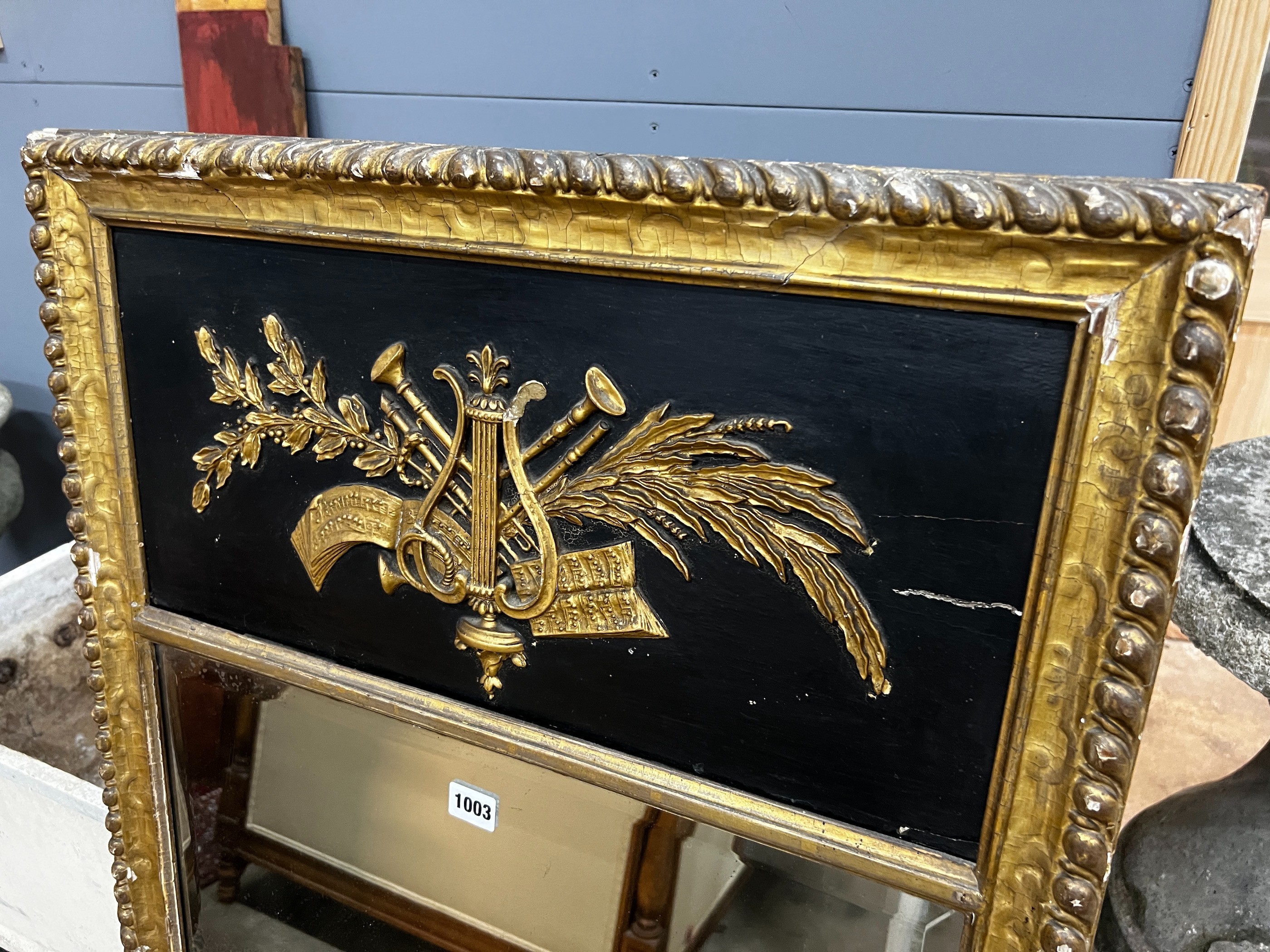 A Regency painted gilt and gesso pier glass with musical trophy tablet, width 62cm, height 124cm